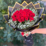 Aynı buketin yukarıdan görünümü; kubbe hâlinde kırmızı güller ve çevreleyen cipso