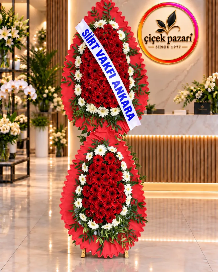 Fırfırlı kırmızı çerçeveli iki katlı ferforje; kırmızı gerberalar, beyaz gerbera halkası ve kurdele