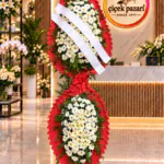 Fırfırlı kırmızı çerçeveli iki katlı ferforje; beyaz papatyalar, kırmızı fiyonk ve tebrik kurdeleleri