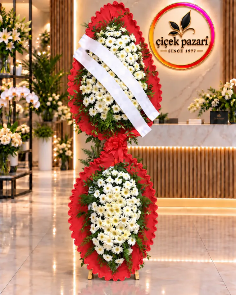 Fırfırlı kırmızı çerçeveli iki katlı ferforje; beyaz papatyalar, kırmızı fiyonk ve tebrik kurdeleleri