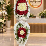 Dilimli beyaz panolu benzer ferforje; kırmızı gerbera, krem papatya, tepede ve etekte beyaz kümeler