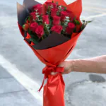 Kırmızı ve siyah katmanlı ambalajda okaliptuslu kırmızı gül buketi, kırmızı saten kurdele