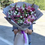 Gri ambalajlı büyük buket; pembe lilyum, bordo-beyaz krizantem, beyaz gül ve mor saten kurdele