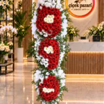 Üç katlı ferforje; dilimli beyaz panolarda kırmızı gerbera, krem papatya ve beyaz çiçek kümeleri